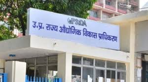 5 - The Journalist News Entrance of a government building with a blue sign in Hindi reading 'U.P. State Industrial Development Authority' above the doorway.