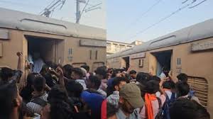 Crowded crowd surrounding a train doorway with passengers boarding or disembarking visible at the open door.
