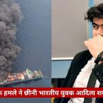 Split-image: left side shows a container ship at sea emitting a large dark smoke plume; right side shows a man in a suit touching his face, seated in an indoor setting; red Hindi news banner at bottom reads a headline.