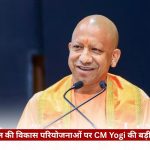 Public figure in orange robes speaking at a microphone on a stage, with a Hindi news banner across the bottom and a 'The Journalist' watermark in the top-right corner.