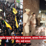 Dense crowd of protesters marching with colorful flags on a city street; police stand by rubble and damaged bricks to the right, indicating a post-incident scene.