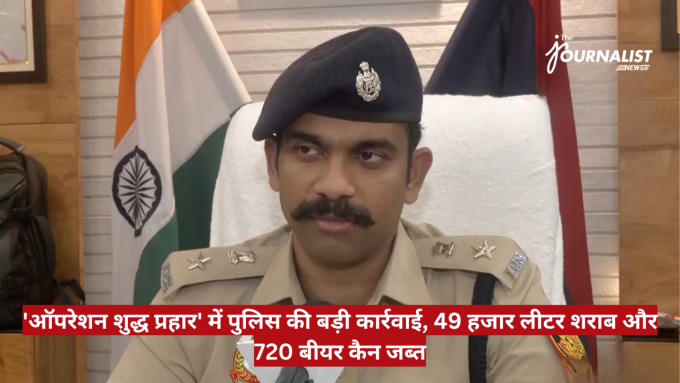 Indian police officer in khaki uniform and beret sits at a desk with Indian flag behind him, during a news briefing.