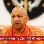 Bald man in orange robes speaking, with a red Hindi news ticker at the bottom of a news-style frame