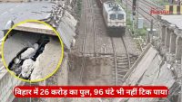 Railway tracks cross a severely damaged bridge with a large gap and broken concrete rubble; a white maintenance vehicle on the tracks, and a red Hindi news banner at the bottom.