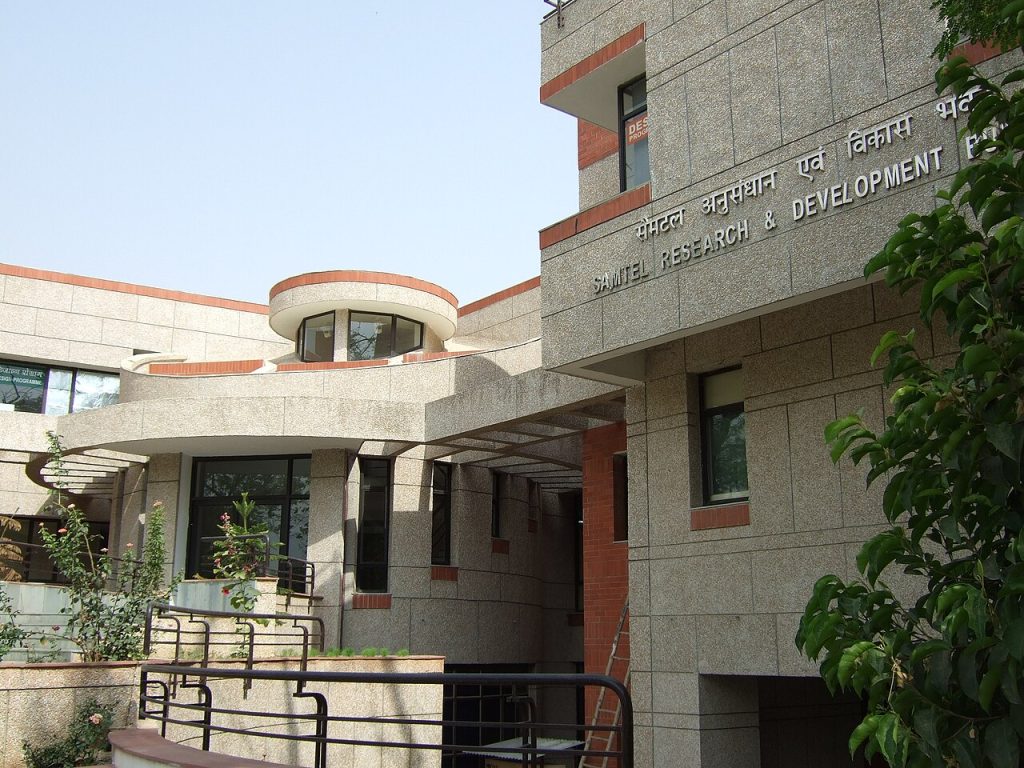 Samtel_Research_and_Development_Building_at_IIT_Kanpur - The Journalist News Front view of a modern stone building with the sign 'SAMUEL RESEARCH & DEVELOPMENT' and a curved white balcony area near the entrance.