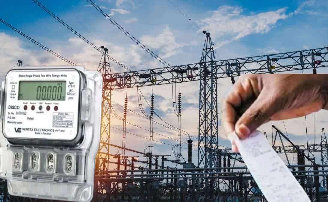 Electric meter in the foreground with a power substation and a hand holding a receipt in the background, suggesting energy billing or usage.