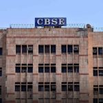 CBSE government building facade with beige tiled walls and many windows, blue CBSE sign atop the roof.