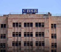 CBSE government building facade with beige tiled walls and many windows, blue CBSE sign atop the roof.