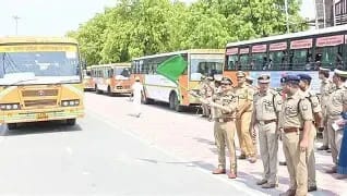 WhatsApp Image 2026-06-08 at 33548 PM 1 - The Journalist News Line of traffic police officers stand in a row beside a fleet of buses on a sunny road, one officer signaling with a green flag to start a procession.