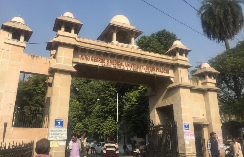 Stone arch gateway to King George's Medical University in Uttar Pradesh, with a sign overhead reading the university name in clear letters.