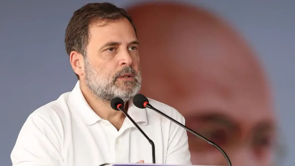 Bearded man in a white polo shirt speaking at a podium with two microphones