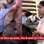 Split-screen news clip: on the left, a man in a blue shirt appears to stumble or fall near rubble; on the right, a female reporter holds a microphone at a street-side news setup, with a Hindi caption bar mentioning a BMC employee incident.