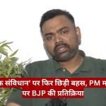 Man in a green polo being interviewed; white wall, plant on left, red Hindi news ticker across the bottom, The Journalist News logo top-right.