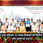 Group of officials and awardees on stage holding certificates at a ceremony, with a floral backdrop and banner in the background.