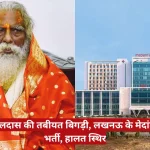 Split image: left an elderly sadhu in orange robes with a white beard; right a Medanta hospital building against a blue sky; red Hindi caption about hospitalization.