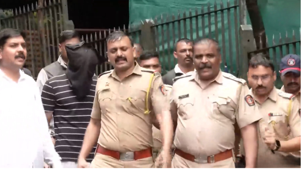 Light Blue and Yellow Bold Month Astrology Horoscope YouTube Thumbnail 40 - The Journalist News Police officers escorting a hooded detainee in front of a green fence, walking with a group of officers nearby.