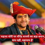 Man in a red traditional turban smiles while speaking at a microphone on a colorful stage; news logo in corner.